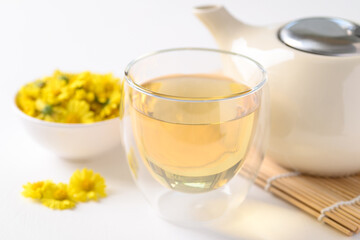 Organic Chrysanthemum flower tea in a cup and teapot on white background, Healthy Herbal drink