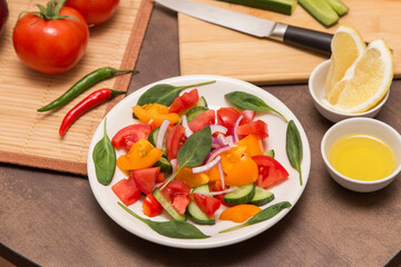Fresh mixed vegetable salad with spinach leaves in white plate close up. Diet, vegan, vegetarian, healthy food