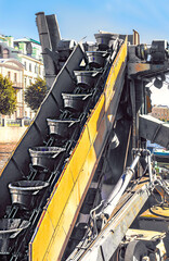 Buckets on a revolving chain to remove large quantities of material, located on the bucket chain excavator (BCE) is a piece of heavy equipment used in surface mining and dredging.