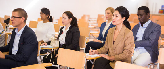 Portrait of focused people of different nationalities during business seminar in conference hall