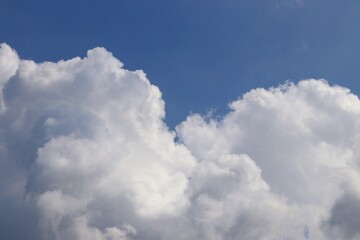 Fototapeta na wymiar Growing white clouds in the blue sky