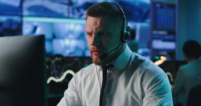 Male employee speaking with client and using computer