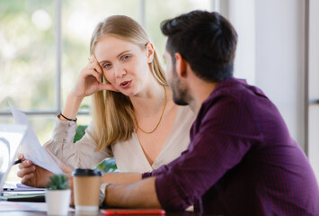 Two businesspeople, man and woman, working together in a modern office in an intimate manner. Idea for teamwork and good business colleagues