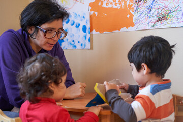 mother teaches her children while drawing.