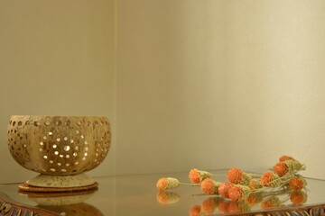 globe amaranth.   
dried flower with coconut Asian candle.  

This antique mahogany side table is made in England. 
dim lighting  room soft focus image.