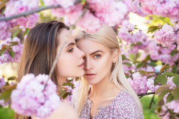 Obraz premium Spring girls fashion. Portrait of a two beautiful sensual sexy woman in cherry blossoms.