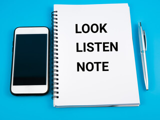 Top view of smartphone, pen and notebook written 