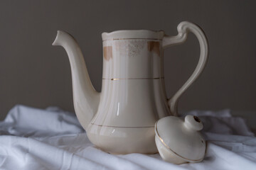 beautiful old tea pot or coffee maker. With a beige background on a white cloth.