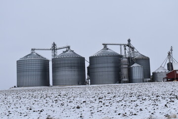 Grain Bins in a Snowy Field © Steve