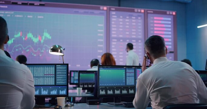 Male trader using computer in stock exchange office