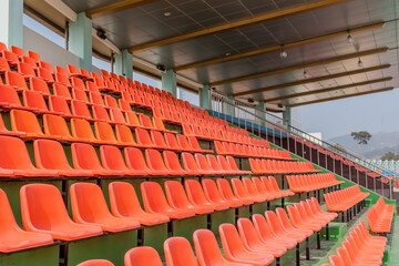 Fototapeta premium Empty orange stadium seats at sports complex