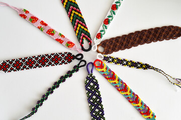 Woven DIY friendship bracelets handmade of embroidery bright thread with knots isolated on white...
