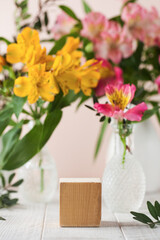 Empty concrete podium for your product presentation with flowers on the background in a spring mood.