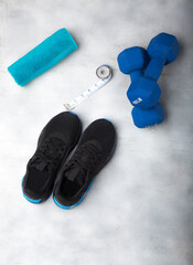 Sports items to start a healthy life, which are: tennis for sports, tape measure, turquoise towel and 10-pound weights.