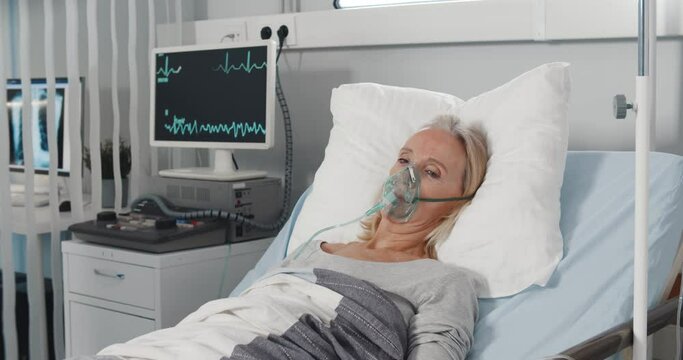 Doctor caring sick patient in hospital checking vital signs on monitor