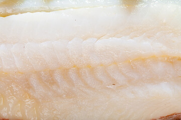 Closeup of raw juicy codfish fillet as natural food background. Cooking ingredients