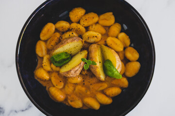vegan gnocchi with dairy-free pumpkin sauce and roasted potatoes with basil