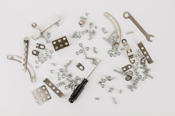 children's iron constructor with nuts and screws and a screwdriver on a white background