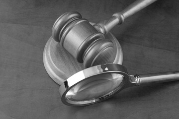 Court and justice review concept. Magnifying glass and judge gavel on table.	