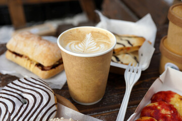Street food and coffee on a wooden table in the street in winter