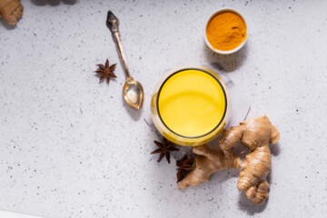 selective focus. Healthy ayurvedic drink golden almond milk or pumpkin turmeric latte with curcuma powder on white background. copy space.Trendy Asian natural detox beverage with spices for vegans