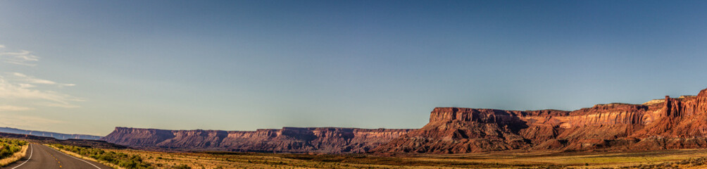 Panorama shot of long orange sandy massif of rock and road to canyonlands in utah, america