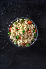 Vegan rice, top shot on a dark black background with copy space