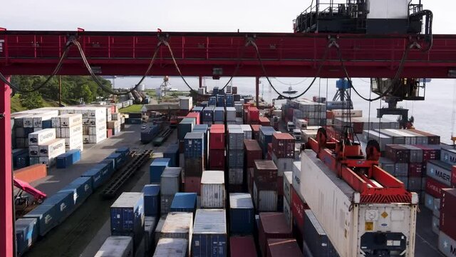 Vladivostok, Russia - 2020, Summer - Vladivostok Commercial Sea Container Port. View from above. A large gantry port crane lifts the container above other cargo. Loading goods onto a ship