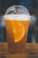 Grapefruit mix orange juice with ice in plastic glass. Cold summer citrus fresh beverage