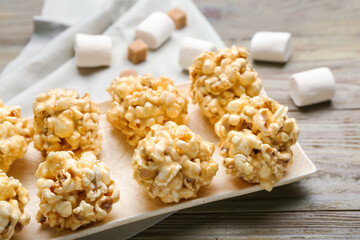 Tray with tasty popcorn balls on wooden background