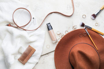 Bottle of makeup foundation and accessories on light background