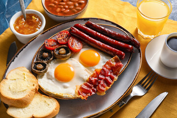 Traditional English breakfast with fried eggs on color background
