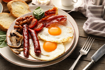 Traditional English breakfast with fried eggs on wooden background