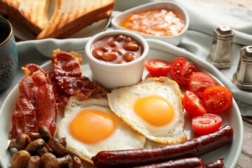 Traditional English breakfast with fried eggs on wooden background