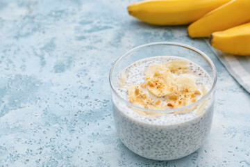 Glass of tasty banana smoothie with chia seeds on color background