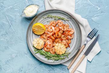 Plate with tasty shrimps on color background