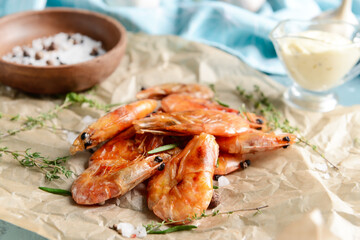 Parchment with tasty shrimps on color background, closeup
