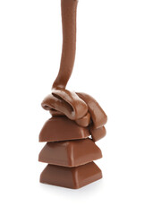 Pouring of melted chocolate on candies against white background