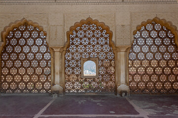 Delicately carved jali perforated stone or latticed screen of Sheesh Mahal, Amber Palace, Jaipur, Rajasthan, India.