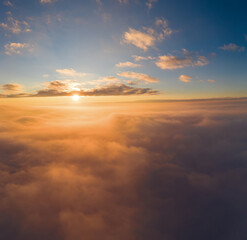 Fototapeta na wymiar view from an airplane on a beautiful saturated sunrise above the clouds