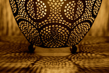 Detail of a Moroccan style table lamp shade.  On a wooden side table