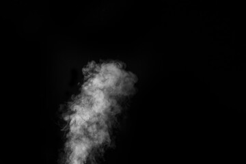 White vapour spray steam from air saturator. Smoke fragments on a black background. Abstract background, design element, for overlay on pictures