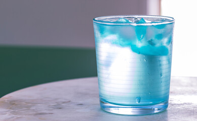 glass of water with ice on blurred background