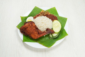 Nasi Lemak dish with chicken drum stick on white wooden verneer