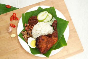 Nasi Lemak dish with chicken drum stick on white wooden verneer