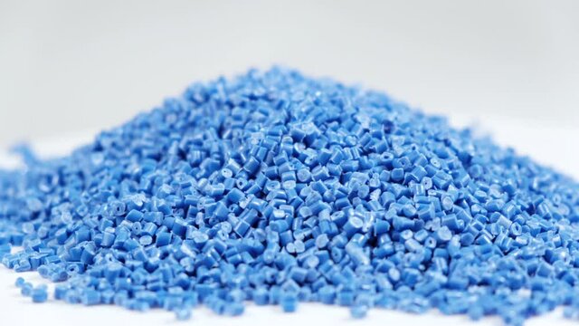 Secondary granule made of polypropylene, Blue Plastic pellets crumbles to the table . Plastic raw materials in granules for industry. Polymer resin. Raw plastic recycling concept