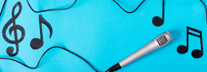 musical concept. musical notes and microphone on a blue background.