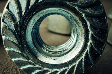 Macro shot of metal nuts on textured surface