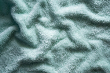 Fototapeta na wymiar Luxuriors green towel fabric or silk abstract background. of texture and pattern of colorful green mess towel fur fabric, top view or flat lay with space for your text.