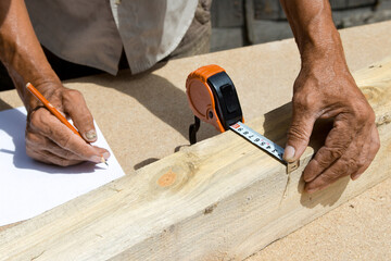 Carpenter inspect the quality of the material and calculate the required quantity for production .Manufacturing of furniture from a natural tree.Employee Uses technology to benefit